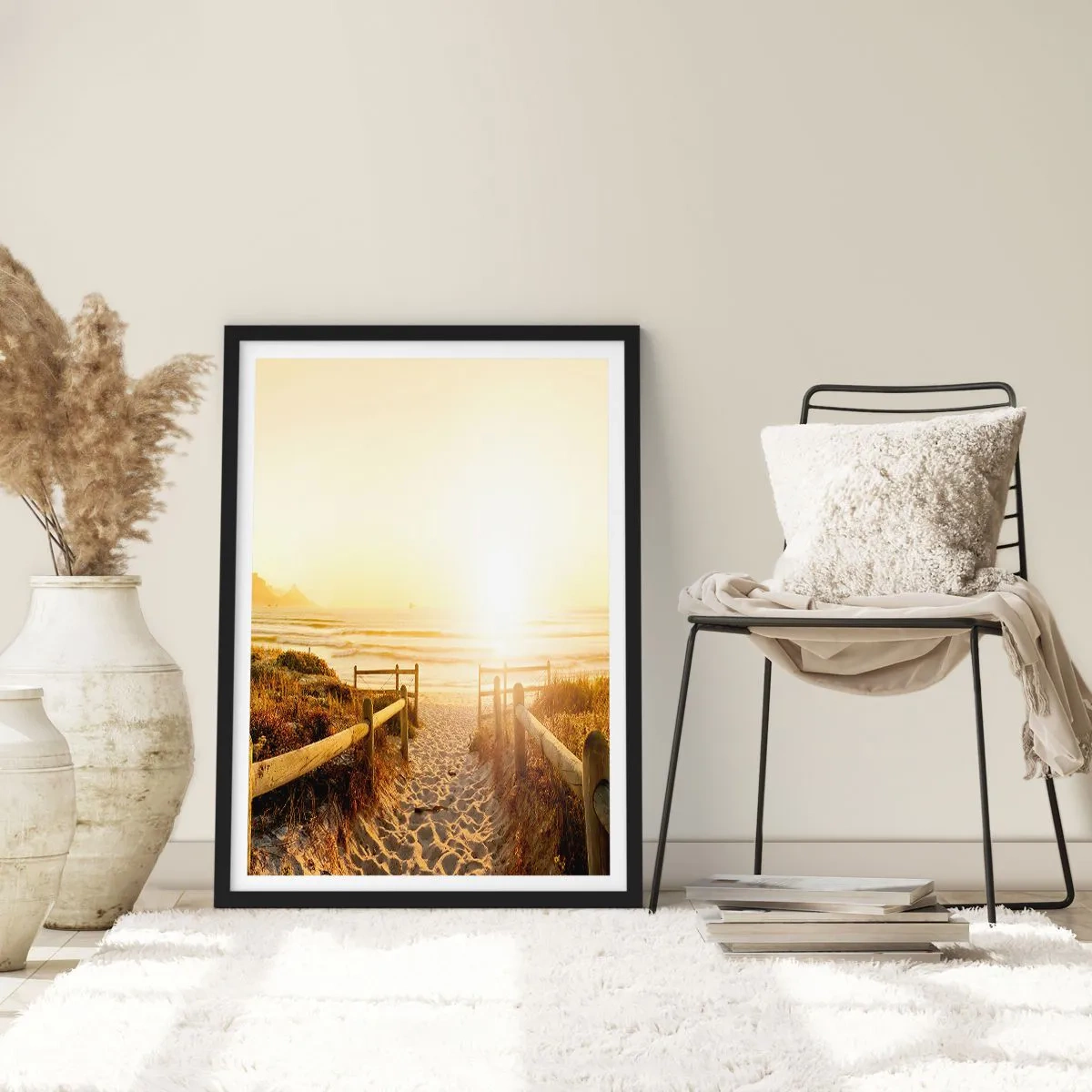 Poszter fehér keretben - A lenyugvó nap sugarai által megvilágított tengerparti út - 50x70cm - A dűnén túl, a nap felé - Modern fali dekoráció nappalihoz és hálószobához ARTTOR