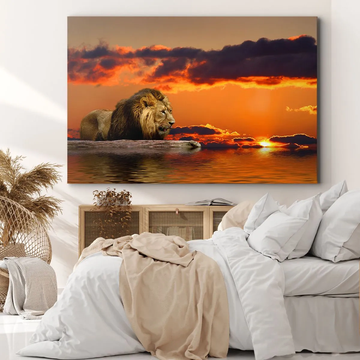 Vászonkép - Egy oroszlán pihen a vízparton naplementekor, drámai égbolttal. - 70x50cm - A természet királya - Modern fali dekoráció nappalihoz és hálószobához ARTTOR