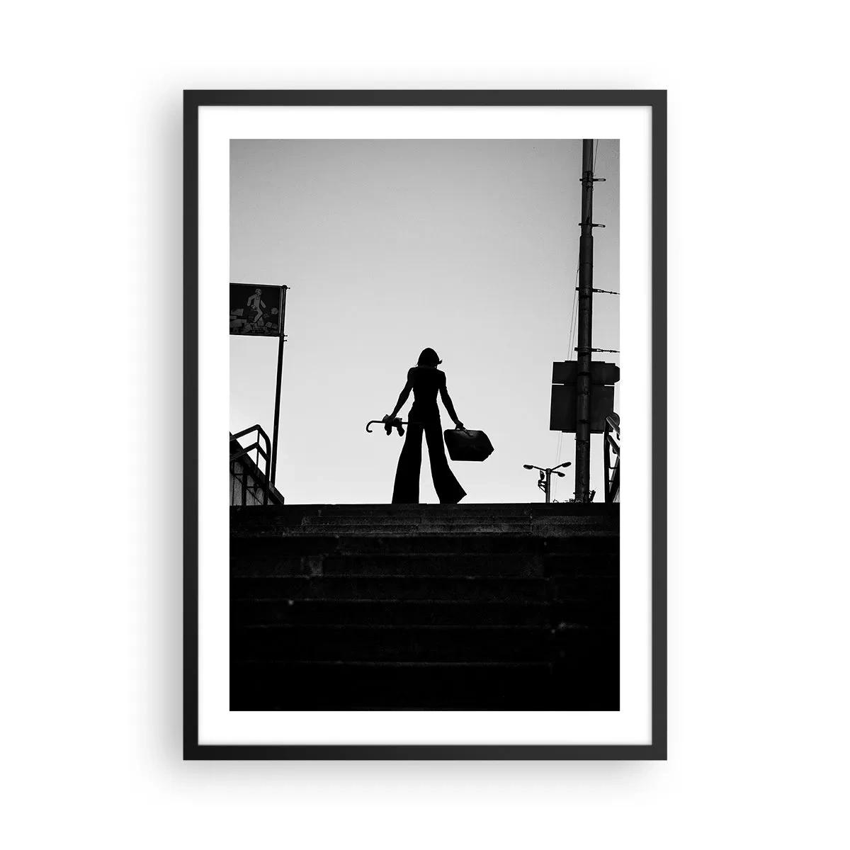 Poszter fehér keretben - Sziluettje egy nőnek egy bőrönddel a lenyugvó nap hátterében - 50x70cm - Városi vándorlás - Modern fali dekoráció nappalihoz és hálószobához ARTTOR