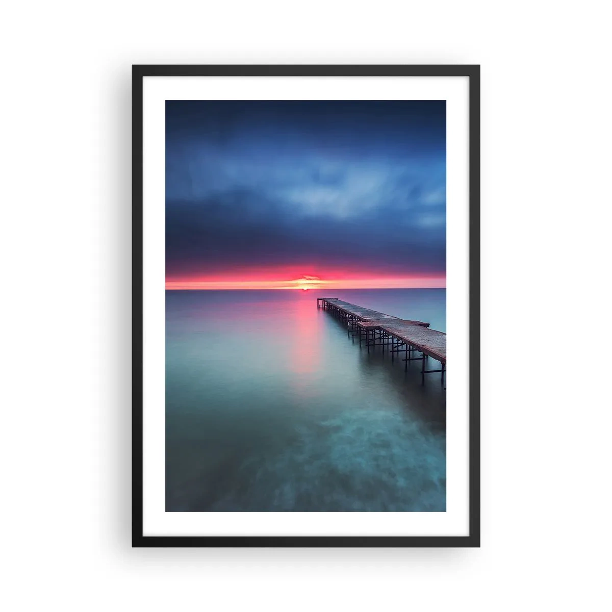 Poszter fehér keretben - Egy móló, amely a nyugodt tengerbe nyúlik naplementekor - 50x70cm - Ég és föld között - Modern fali dekoráció nappalihoz és hálószobához ARTTOR