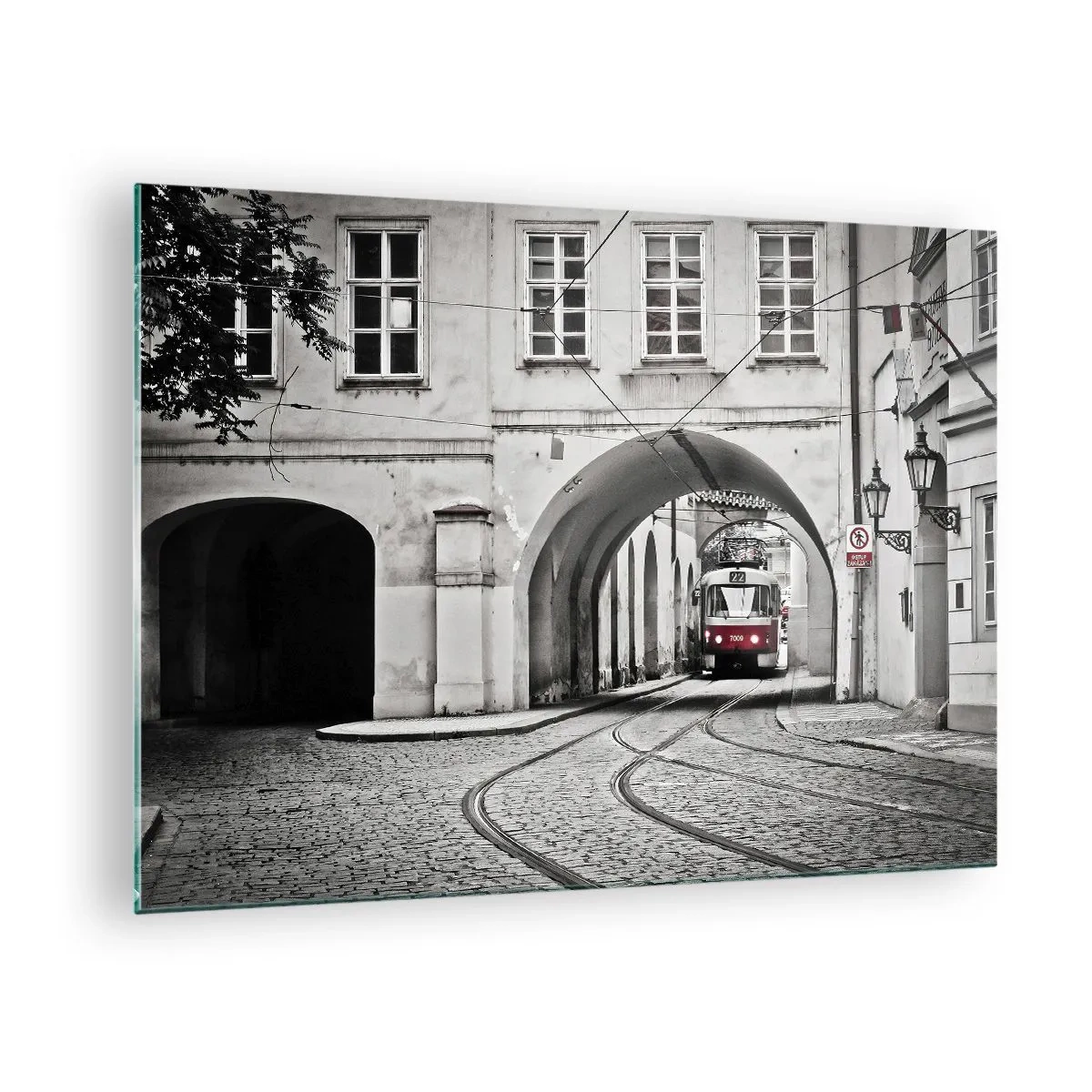 Üveg kép - Fekete-fehér villamos egy régi utcában - 70x50cm - A város labirintusán keresztül - Modern fali dekoráció nappalihoz és hálószobához ARTTOR