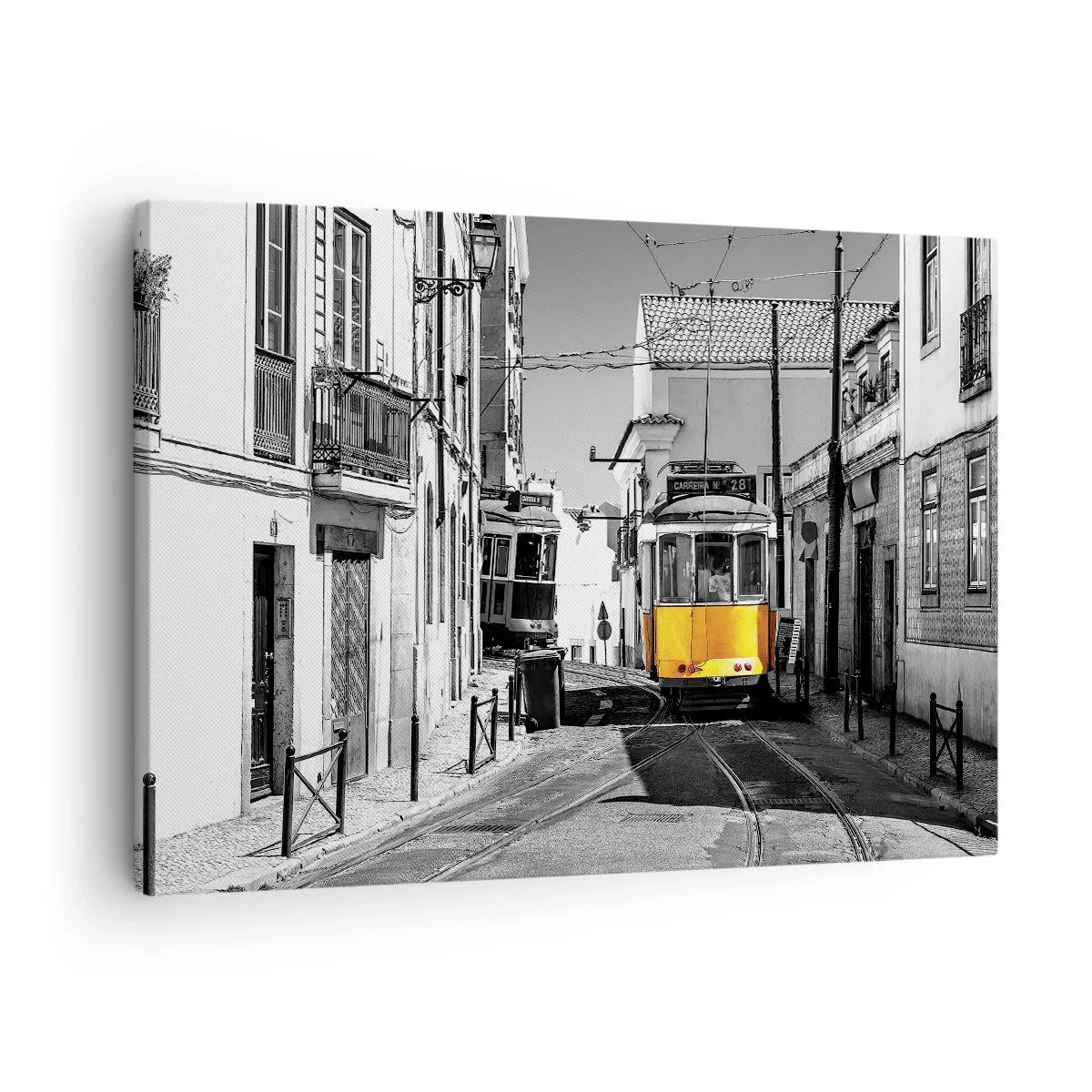 Vászonkép - Egy sárga villamos Lisszabon utcáin monokróm környezetben - 70x50cm - Lisszabon szelleme - Modern fali dekoráció nappalihoz és hálószobához ARTTOR
