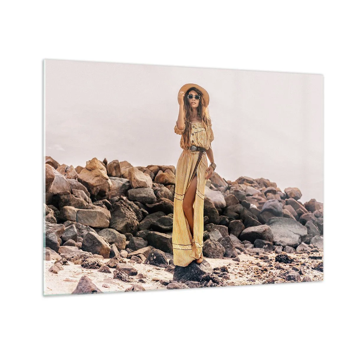 Üveg kép - Egy nő bohém stílusú ruhában, sziklás parton - 70x50cm - A kövek varázsa - Modern fali dekoráció nappalihoz és hálószobához ARTTOR
