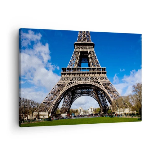 Vászonkép - Az Eiffel-torony a kék ég és egy zöld park hátterében - 70x50cm - Egész Párizs a lábainál - Modern fali dekoráció nappalihoz és hálószobához ARTTOR