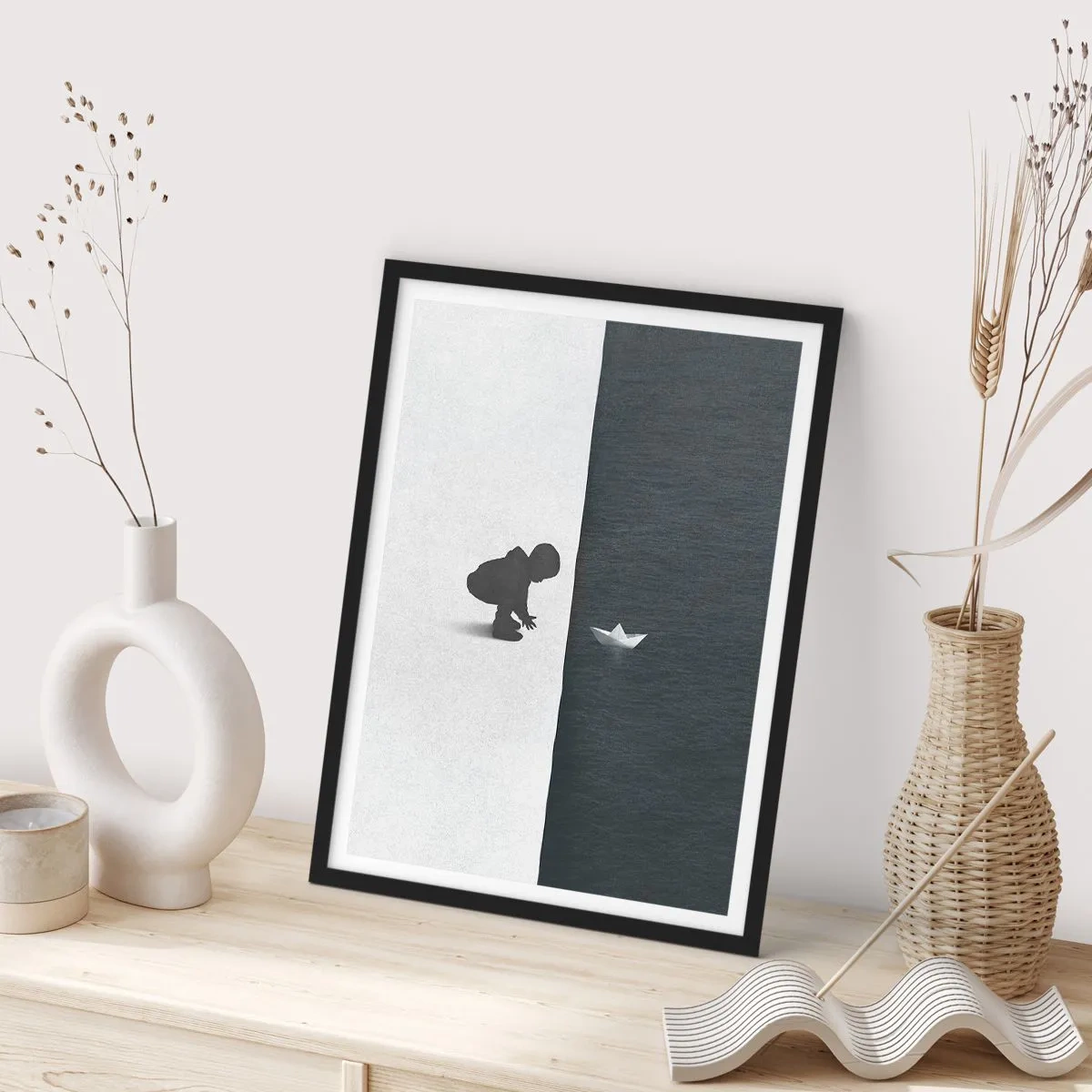 Poszter fehér keretben - Egy gyermek papírhajóval a víz fölé hajol - 50x70cm - Nagy utazás - Modern fali dekoráció nappalihoz és hálószobához ARTTOR