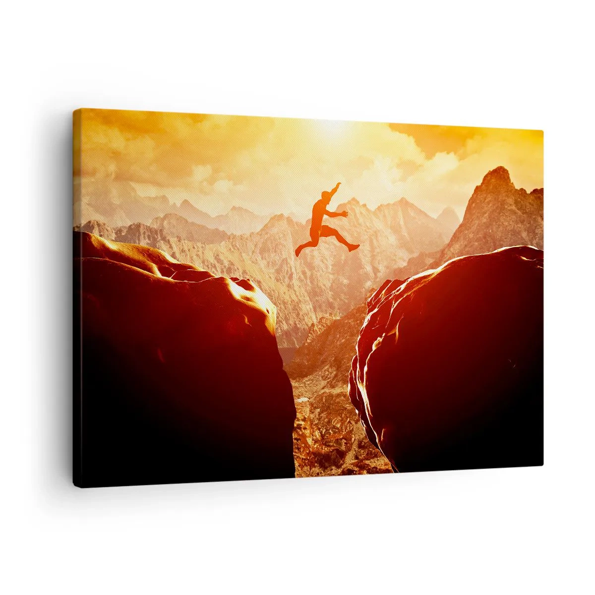 Vászonkép - Egy alak ugrik a sziklák között, a háttérben hegyekkel - 70x50cm - Átlépve a határokat - Modern fali dekoráció nappalihoz és hálószobához ARTTOR