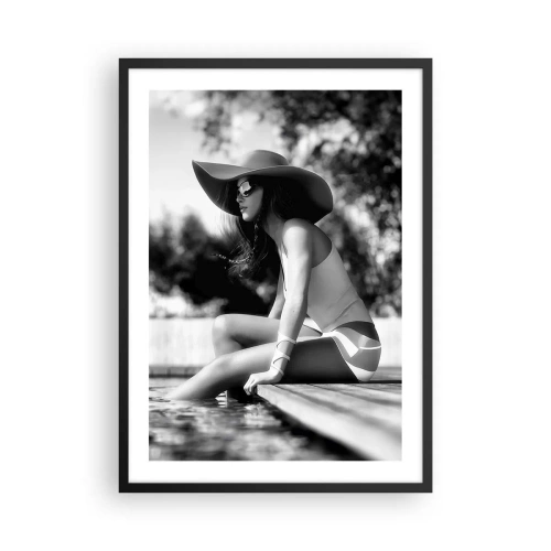 Poszter fehér keretben - Egy fekete-fehér fénykép egy kalapban ülő nőről a vízparton. - 50x70cm - Egy nyári álom - Modern fali dekoráció nappalihoz és hálószobához ARTTOR