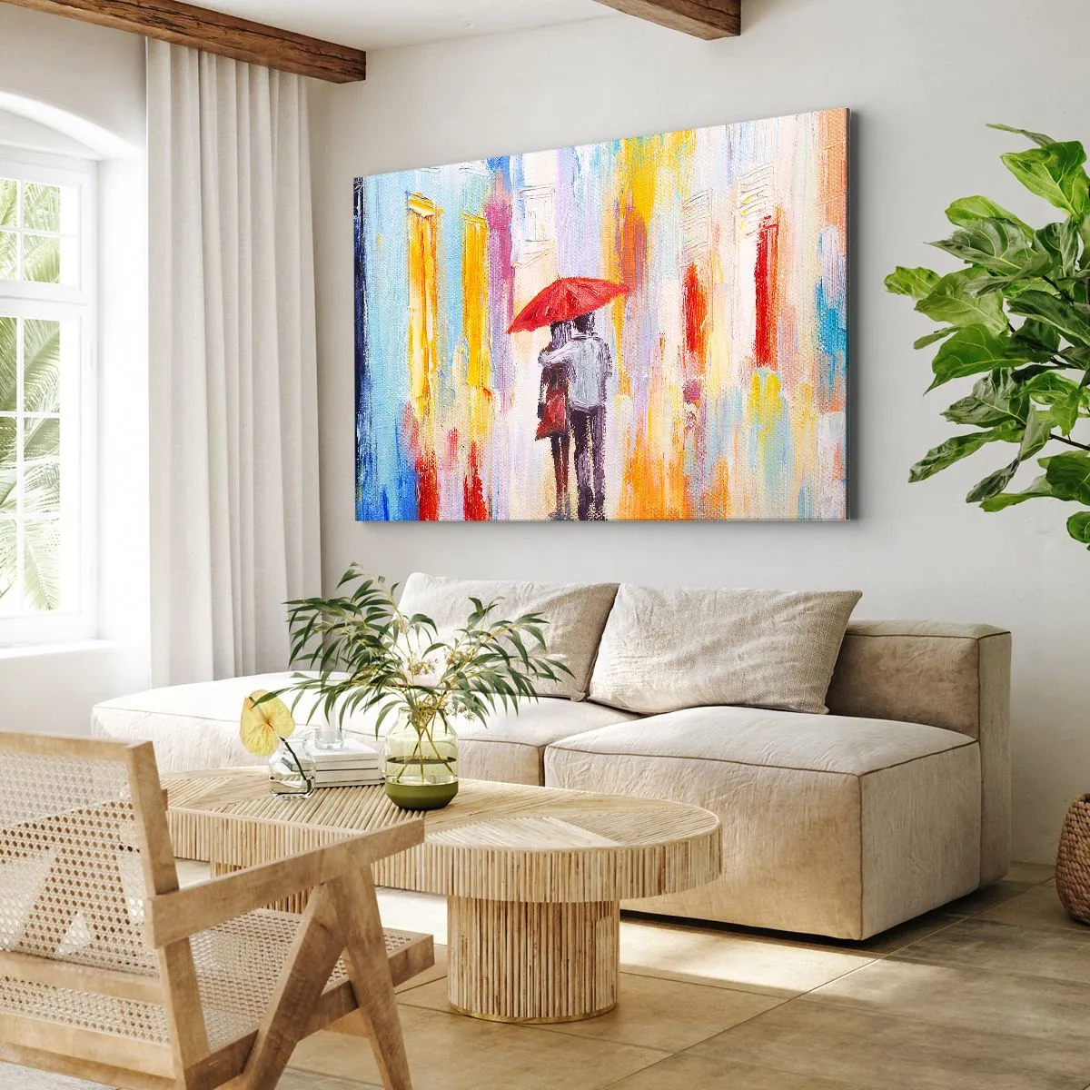 Vászonkép - Egy pár egy piros esernyő alatt, színes épületekkel a háttérben. - 70x50cm - Hadd essen az eső - Modern fali dekoráció nappalihoz és hálószobához ARTTOR