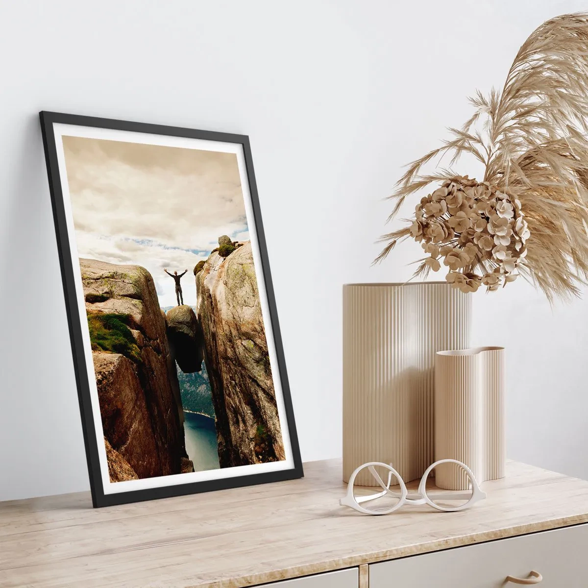 Poszter fehér keretben - Egy férfi egy sziklán áll, amely a sziklák között lebeg - 50x70cm - Hogy vagyok ?! - Modern fali dekoráció nappalihoz és hálószobához ARTTOR