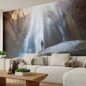 Fotótapéta Standard Eco - Egy vízesés a hegyek között, egy sziklán álló férfi sziluettjével - 100x70cm - Az arányok helyreállítása - Modern fali dekoráció nappalihoz és hálószobához ARTTOR