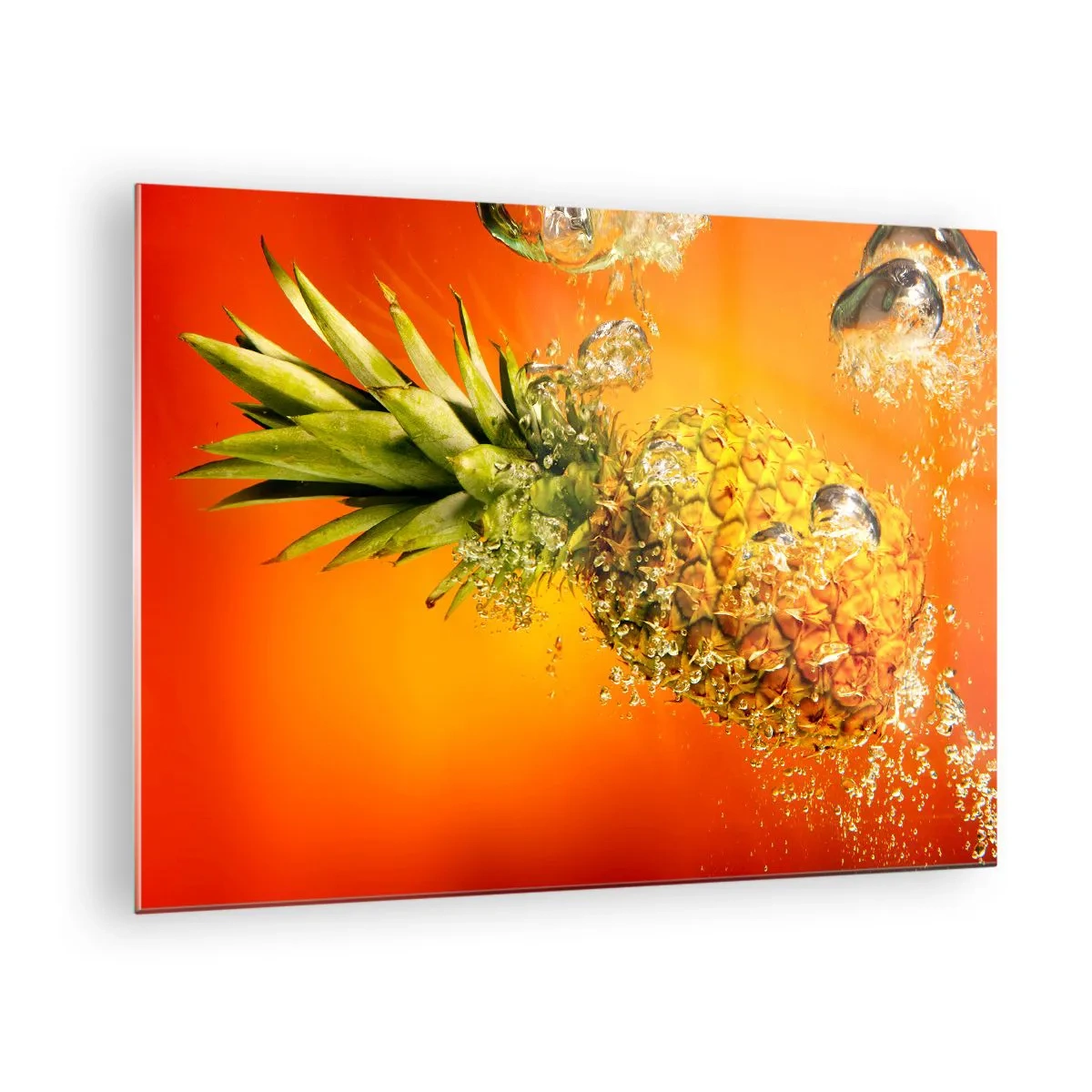 Üveg kép - Ananász vízbe merítve intenzív narancssárga háttér előtt - 70x50cm - Trópusi lédús frissesség - Modern fali dekoráció nappalihoz és hálószobához ARTTOR