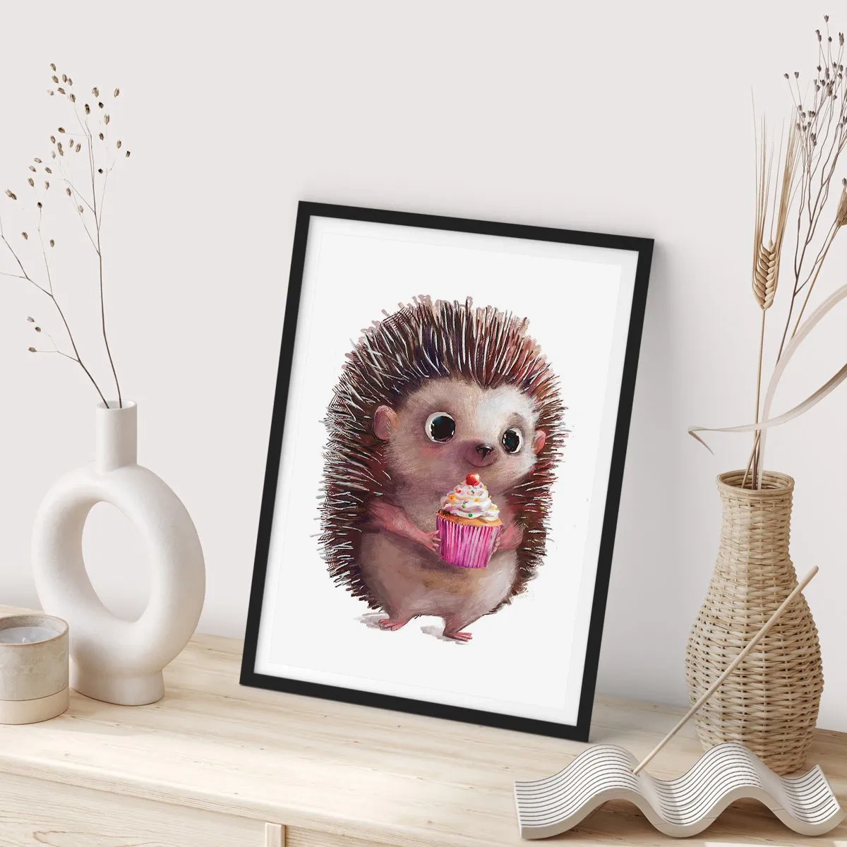 Poszter fehér keretben - Egy aranyos sündisznó tartja a színes cupcake-et - 50x70cm - Ünnep van minden nap - Modern fali dekoráció nappalihoz és hálószobához ARTTOR