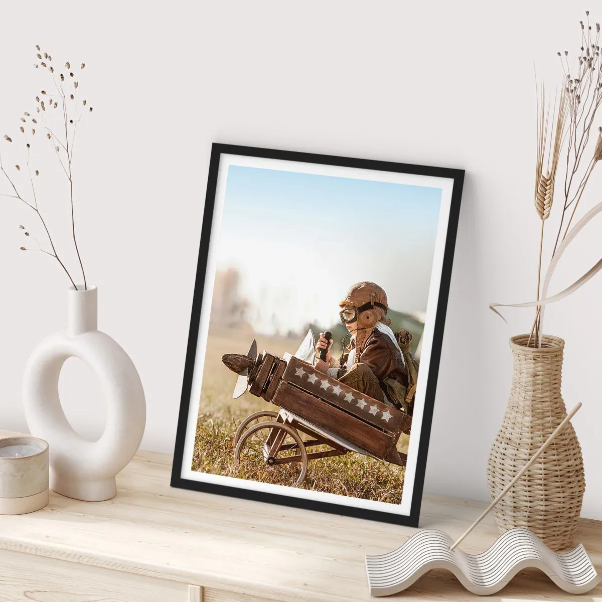 Poszter fehér keretben - Egy gyerek egy fa repülőgépen, csillagokkal a háttérben - 50x70cm - Indulás egy álom felé - Modern fali dekoráció nappalihoz és hálószobához ARTTOR