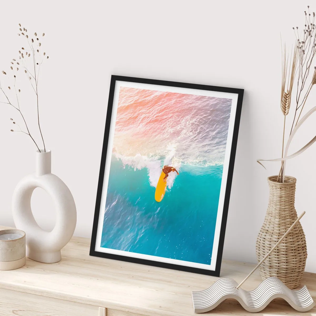 Poszter fehér keretben - Egy szörfös lovagol egy hullámot a lenyugvó nap sugaraiban - 50x70cm - Az óceánlovas - Modern fali dekoráció nappalihoz és hálószobához ARTTOR