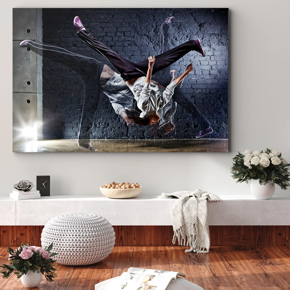Vászonkép - Egy táncos dinamikus ugrásban egy téglafalnak - 70x50cm - Utcai sztár - Modern fali dekoráció nappalihoz és hálószobához ARTTOR