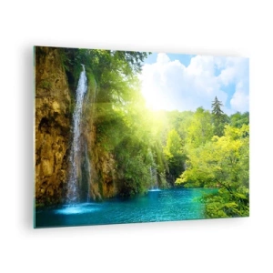 Üveg kép - Egy vízesés, amely egy zöld növényzettel körülvett kék tóba ömlik - 70x50cm - Ez kell legyen a Paradicsom - Modern fali dekoráció nappalihoz és hálószobához ARTTOR