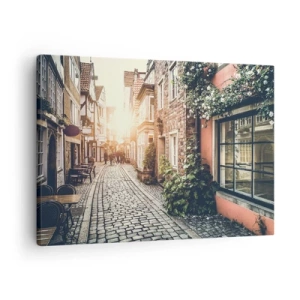 Vászonkép - Egy bájos utca kőburkolattal és virágokkal - 70x50cm - Rózsa sikátor rózsaszín fényben - Modern fali dekoráció nappalihoz és hálószobához ARTTOR