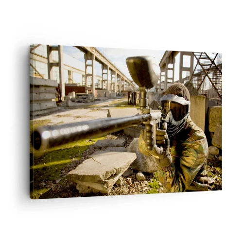 Vászonkép - Egy álcázófelszerelésben lévő paintball-játékos egy jelölővel céloz - 70x50cm - Te is hős lehetsz - Modern fali dekoráció nappalihoz és hálószobához ARTTOR