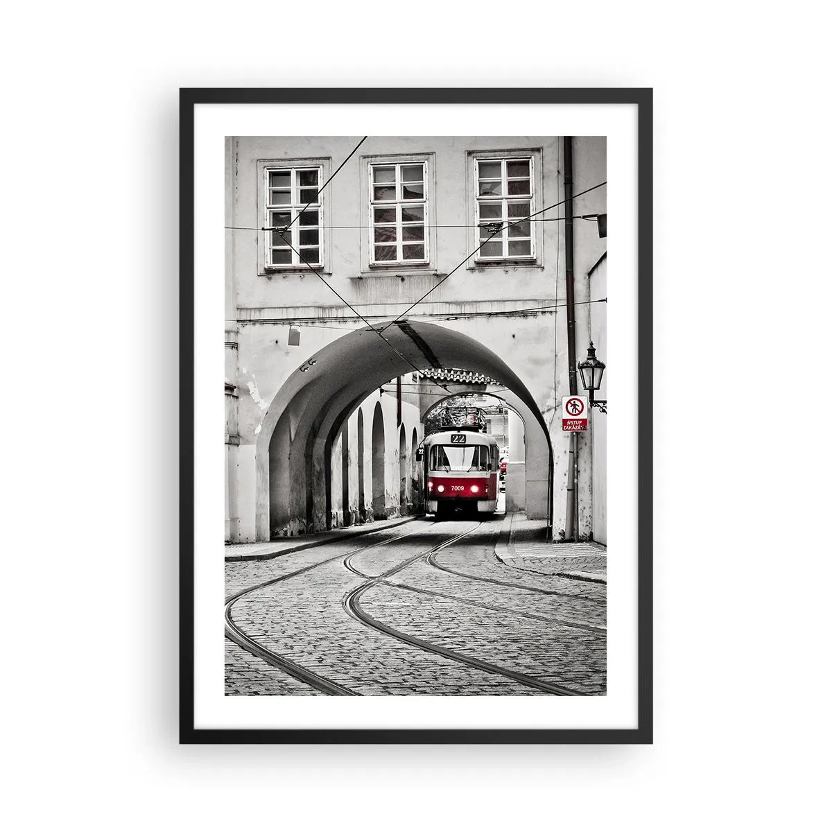 Poszter fehér keretben - Piros villamos fekete-fehér környezetben - 50x70cm - A város labirintusán keresztül - Modern fali dekoráció nappalihoz és hálószobához ARTTOR